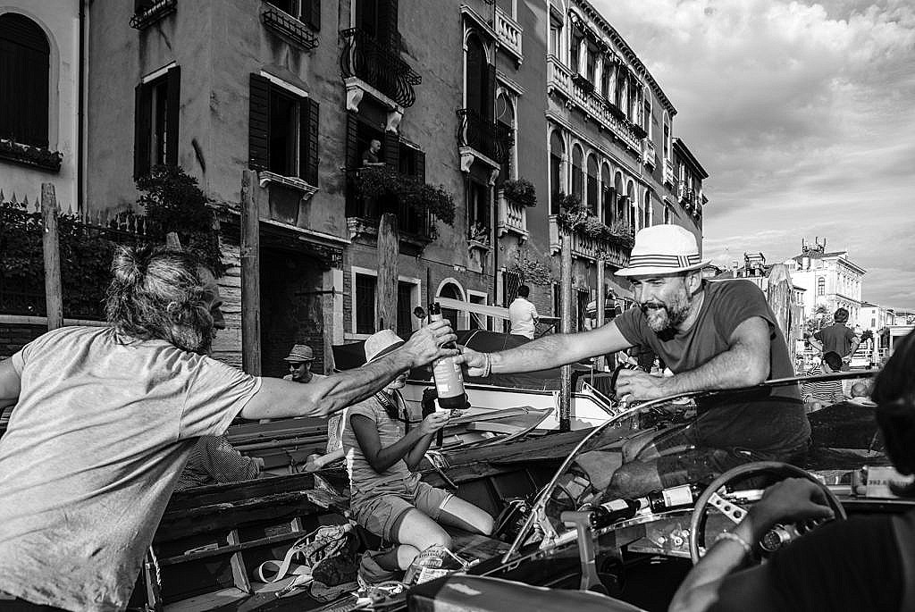 Pass the bottle, please. A group of Venetian friends in boats waiting for the Regata Storica 2018 on the Grand Canal